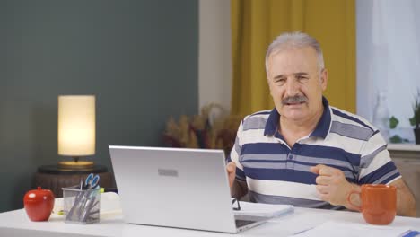 Home-office-worker-old-man-looking-nervously-at-camera.